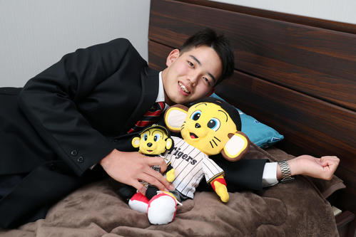 入寮で持ち込んだトラッキーとキー太のぬいぐるみを手に笑顔を見せる阪神ドラフト4位の早瀬（撮影・前田充）