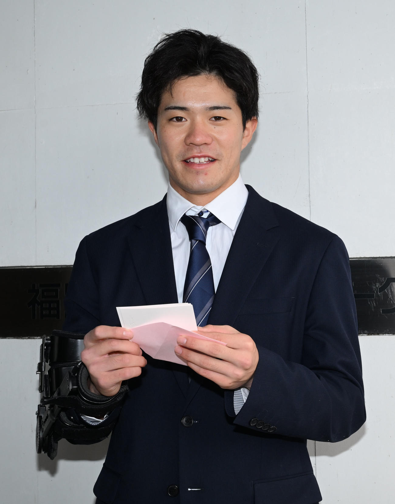 家族からの手紙を手に笑顔で撮影に応じるソフトバンクの相良（撮影・林敢治）