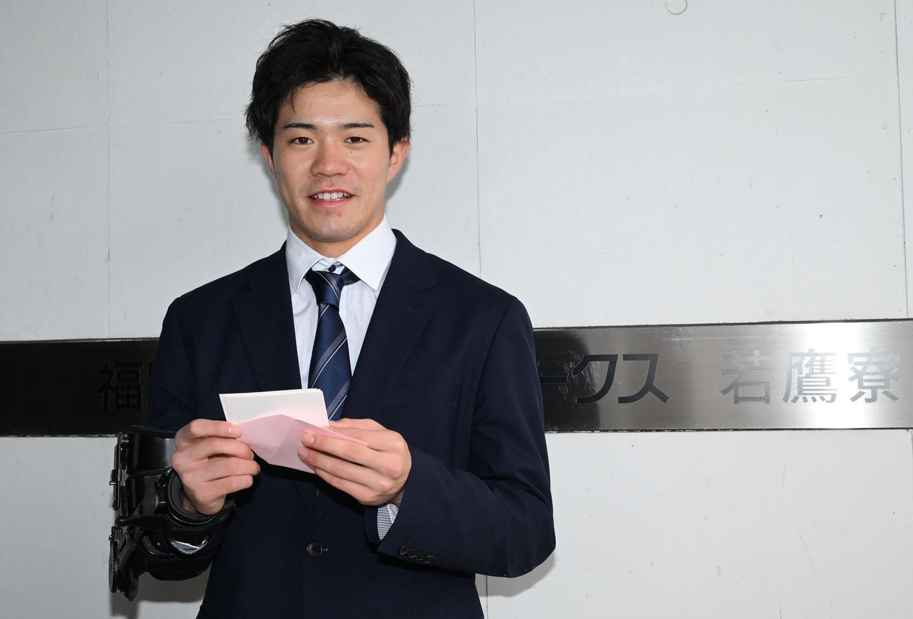 家族からの手紙を手に笑顔で撮影に応じるソフトバンクの相良（撮影・林敢治）
