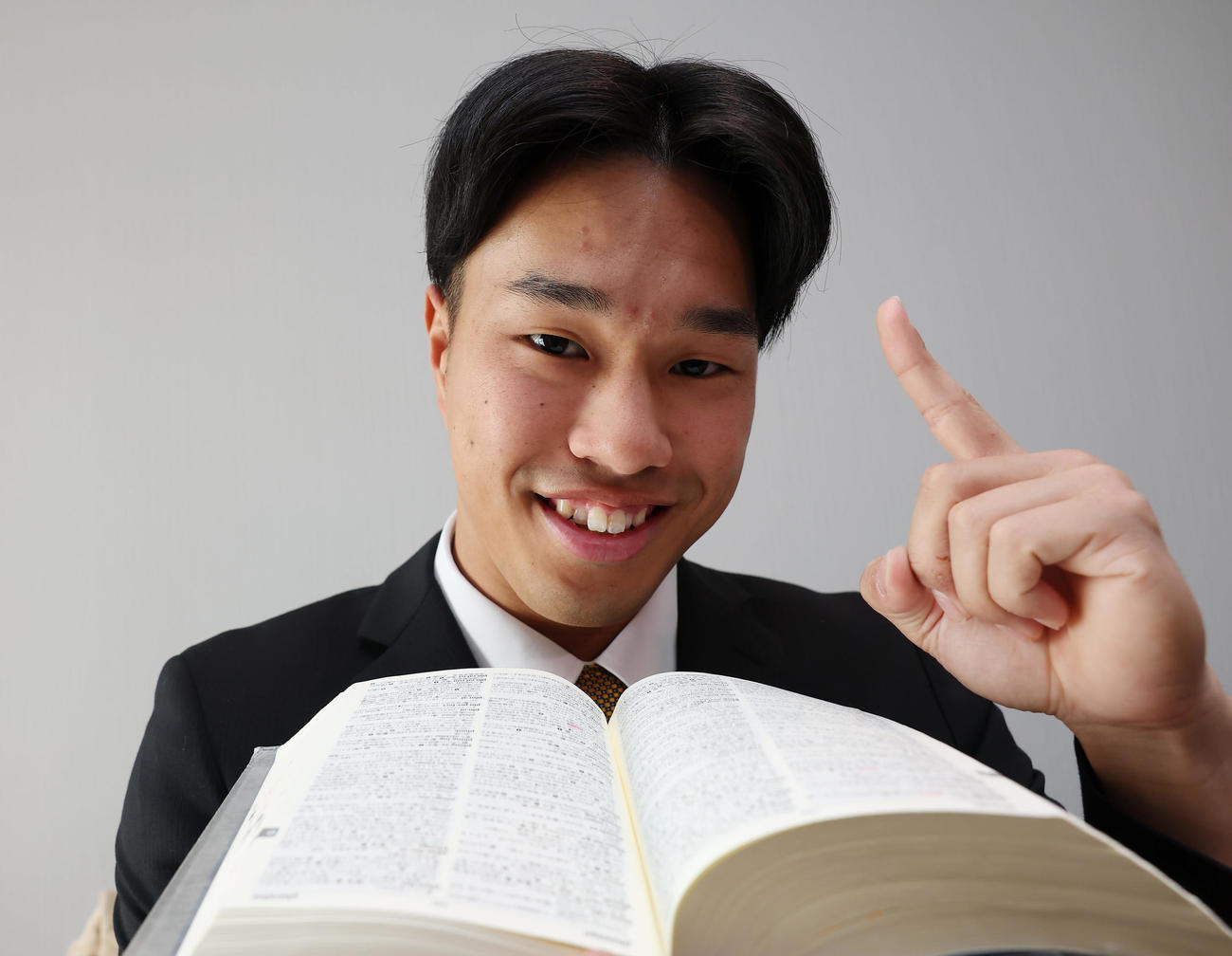 入寮で持ち込んだ英和辞書を手に笑顔を見せる阪神ドラフト3位の岡城