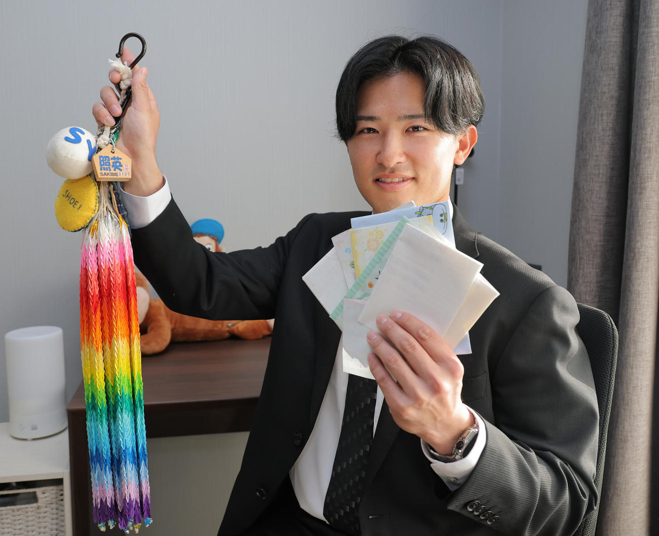 母に作ってもらったお守り（左）とファンレターを持って虎風荘に入寮する阪神育成ドラフト2位の山崎照英