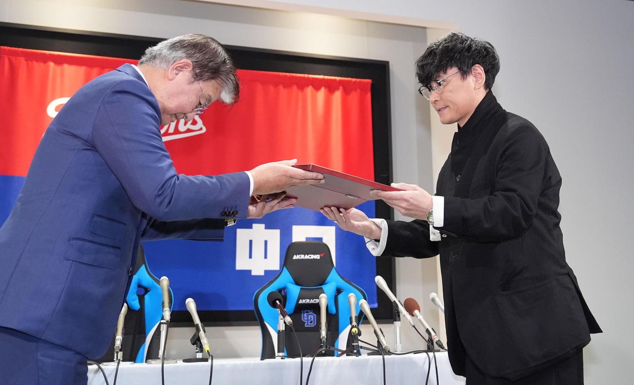 ドラゴンズ90周年広報アンバサダーに就任し加藤球団社長（左）から委任状を受け取るサカナクションの山口一郎（撮影・森本幸一）