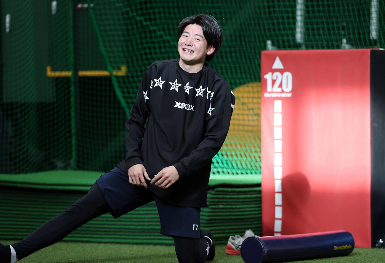 室内練習場でストレッチを始めた巨人竹丸は、報道陣を見て照れ笑い（撮影・浅見桂子）