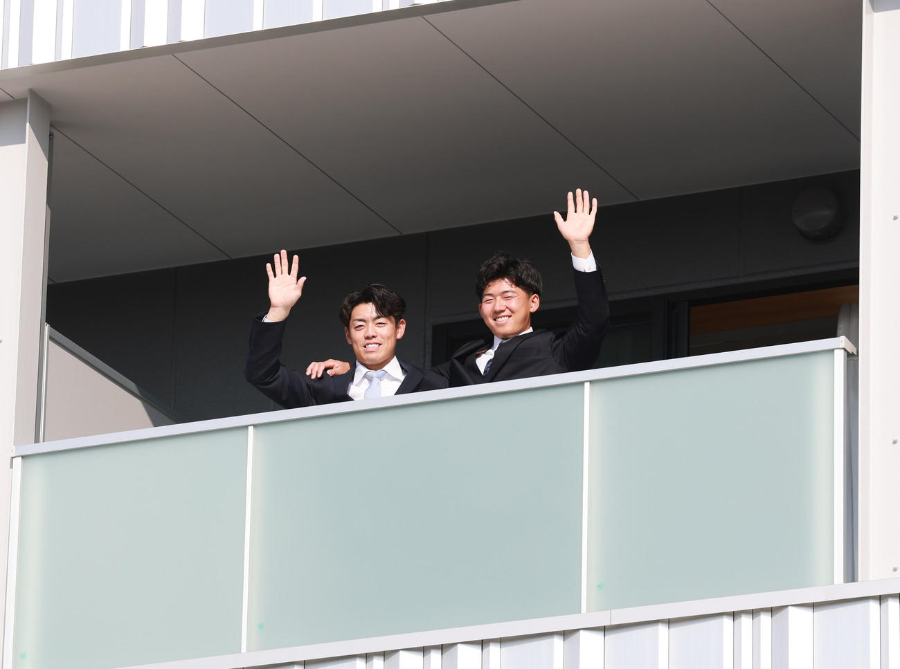 虎風荘に入寮した阪神ドラフト1位の立石（右）と2位の谷端はバルコニーで笑顔を見せる（撮影・上田博志）
