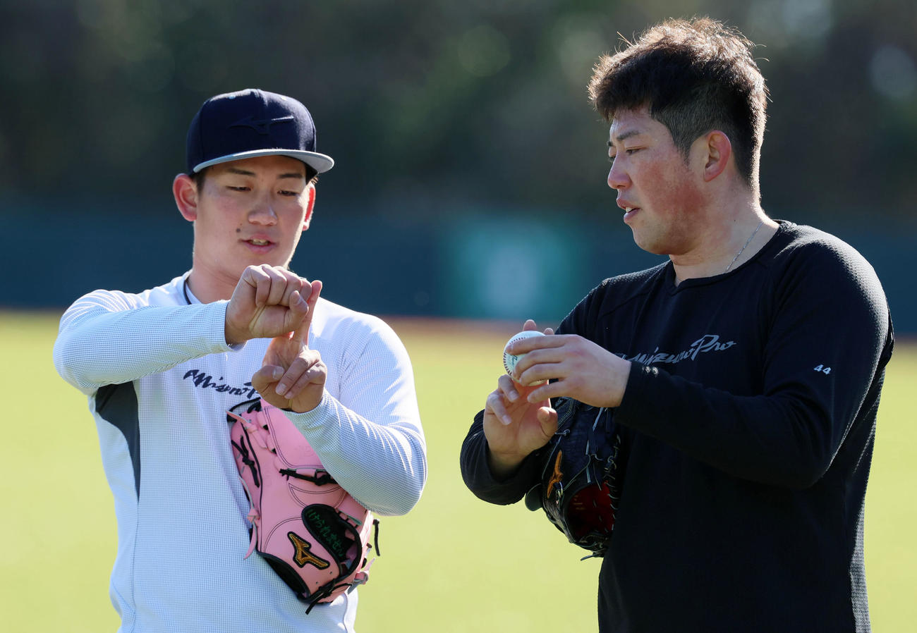 ヤクルト大西（右）と自主トレを行っている阪神伊原はボールの握りなどについて耳を傾ける（撮影・加藤哉）