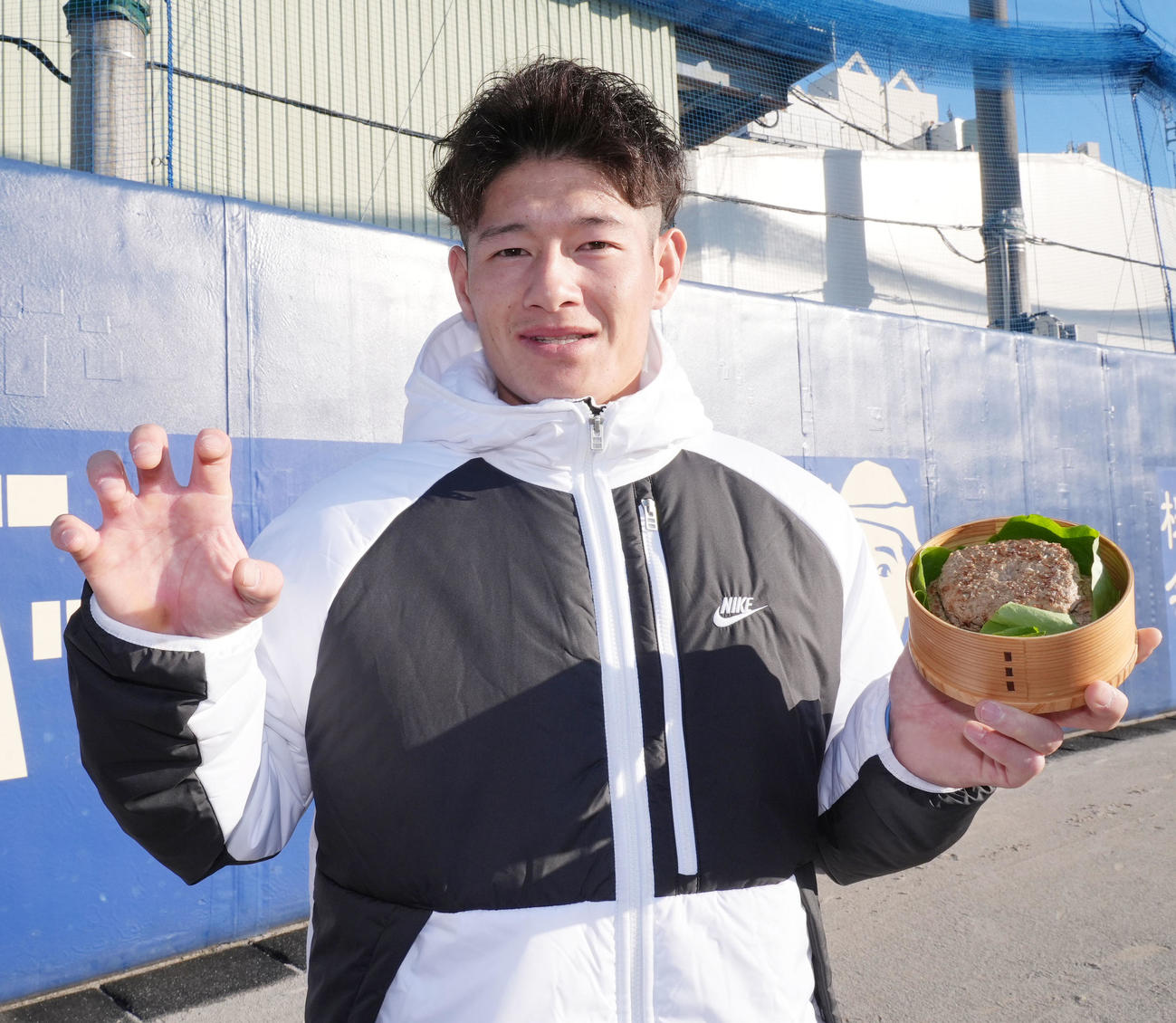 母親から手渡された手作りハンバーグを手にする新保（撮影・森本幸一）