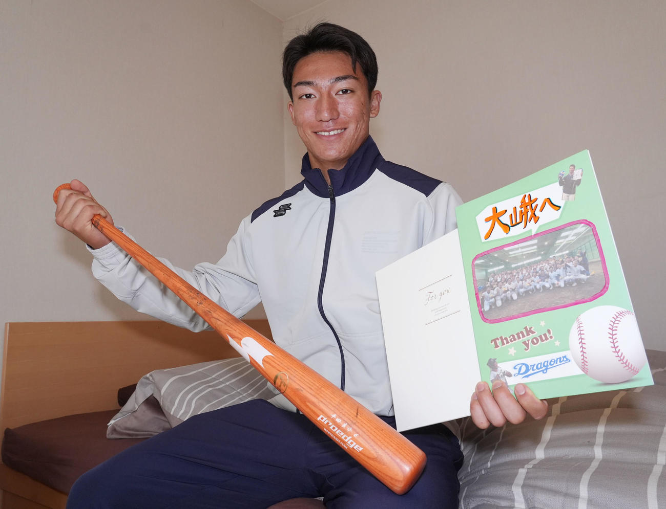 仲間からの寄せ書きと平田良介コーチのバットを手にする石川大（撮影・森本幸一）