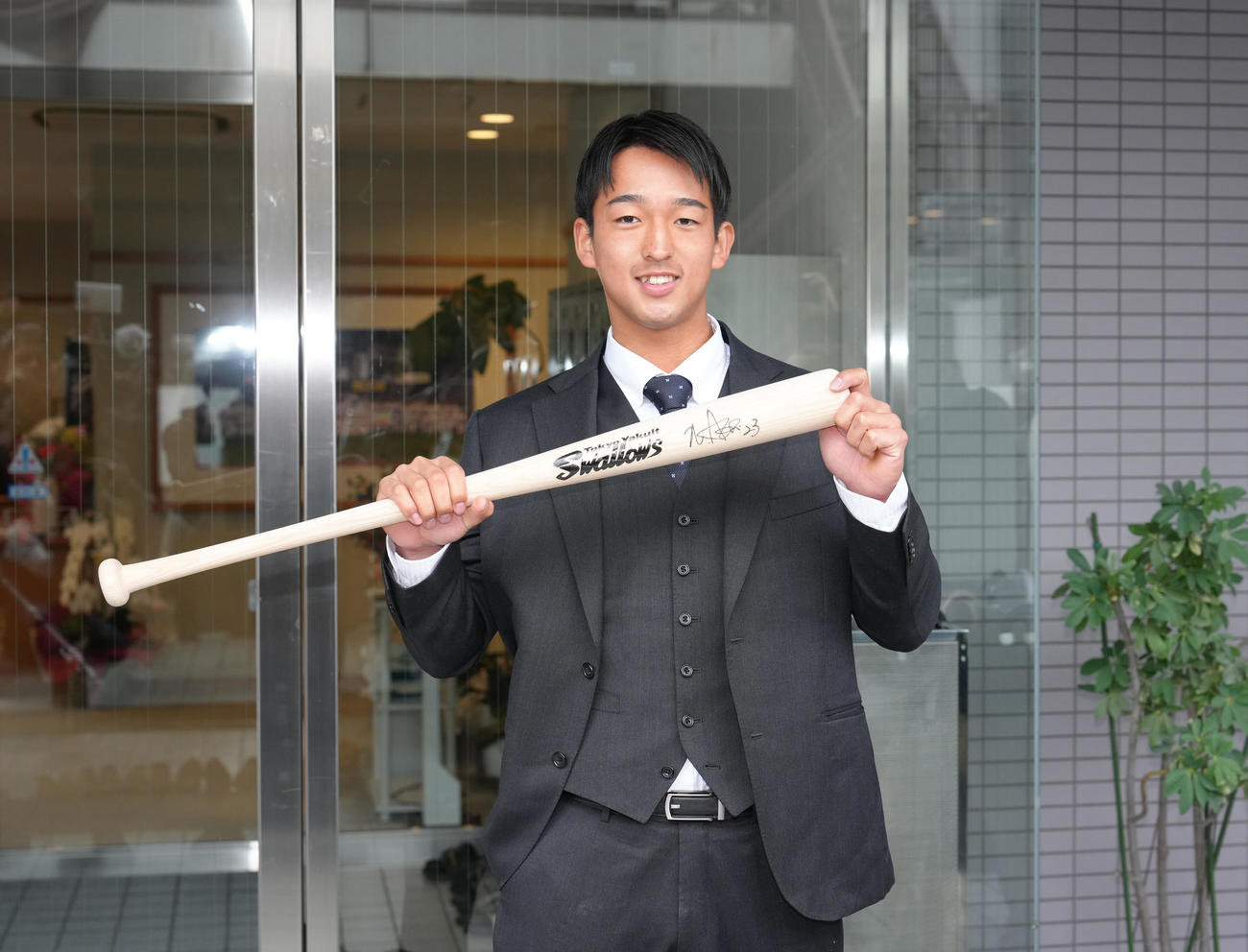 ヤクルト戸田寮に入寮し、青木GMからプレゼントされたサイン入りバットを披露するドラフト1位松下（撮影・足立雅史）
