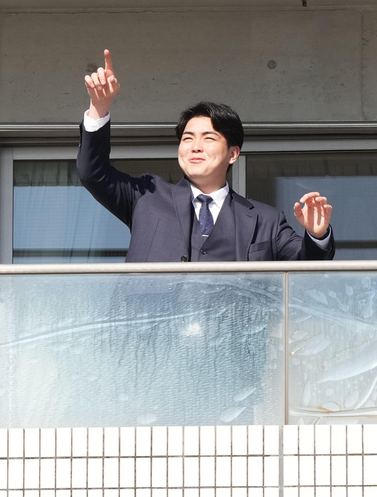 入寮し部屋のベランダから球場を指さす中西（撮影・森本幸一）