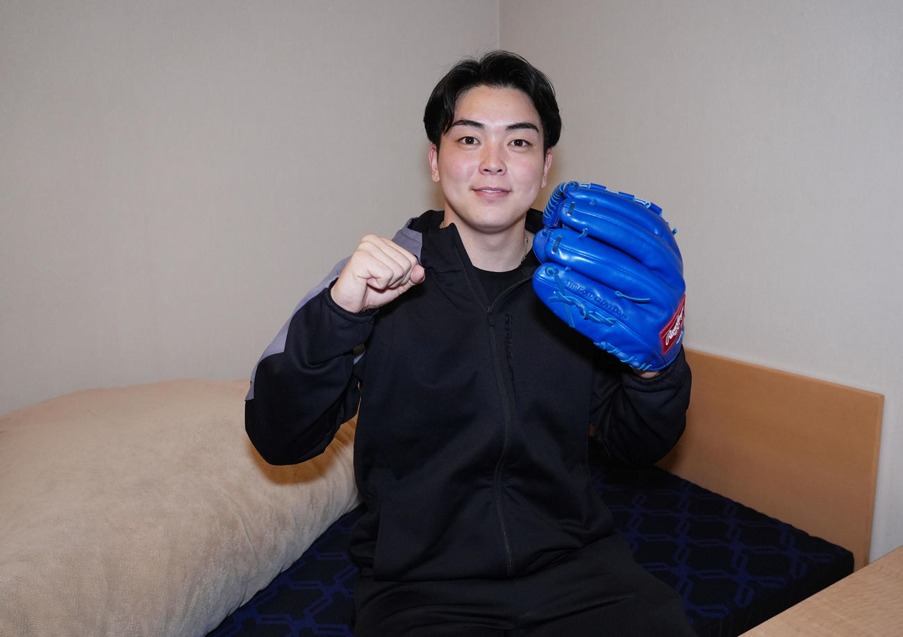 入寮し部屋でグラブを手にする中西（撮影・森本幸一）