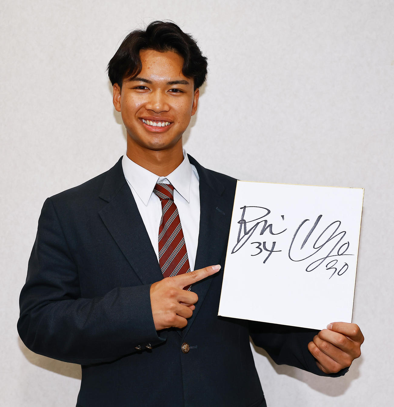 昌平高の同級生で、Jリーグ川崎入りする長と湘南入りする山口のサイン色紙を持参し入寮するロッテドラフト4位の桜井（撮影・野上伸悟）