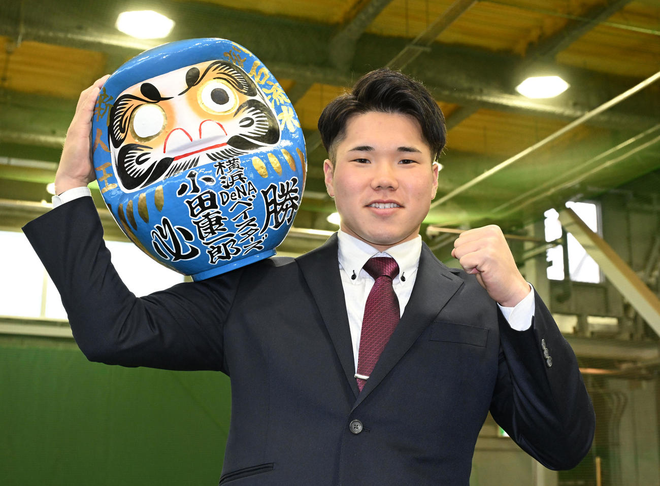 DeNAの選手寮に入寮し、持参しただるまを手にポーズをとる、ドラフト1位の小田（撮影・千葉一成）
