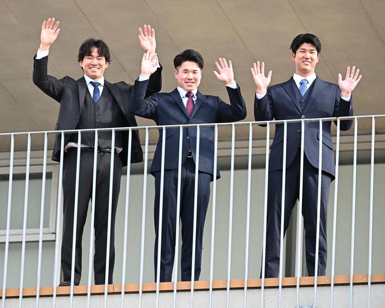 DeNAの選手寮に入寮し、テラスから手を振る、左から宮下、小田、島田（撮影・千葉一成）