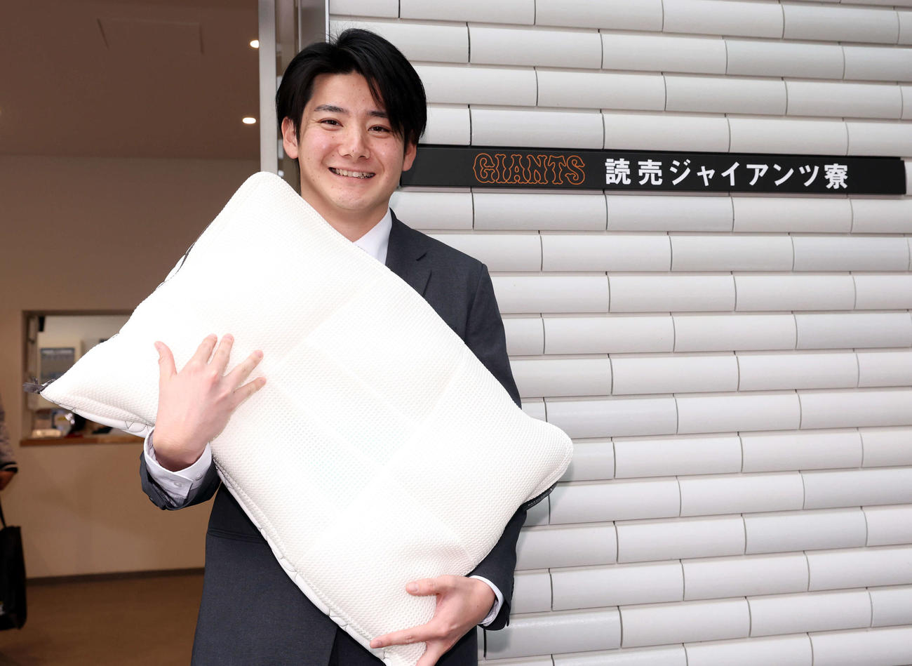 入寮した巨人ドラフト1位の竹丸は持参した枕を抱きかかえ笑顔（撮影・浅見桂子）