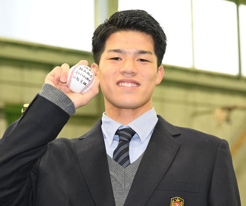 DeNAの選手寮に入寮し、京都国際高校野球部の小牧監督から贈られたメッセージ入りボールを手にポーズをとる育成1位の清水（撮影・千葉一成）