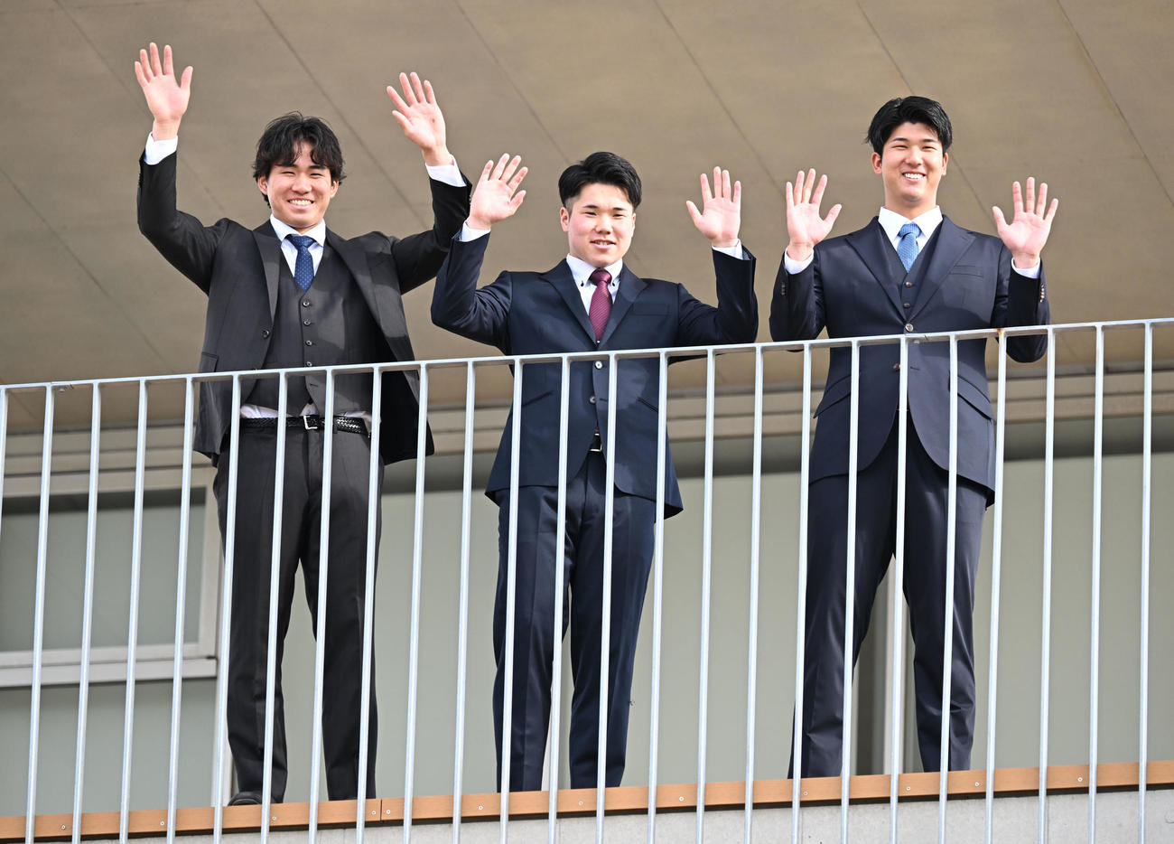 DeNAの選手寮に入寮し、テラスから手を振る、左から宮下、小田、島田（撮影・千葉一成）