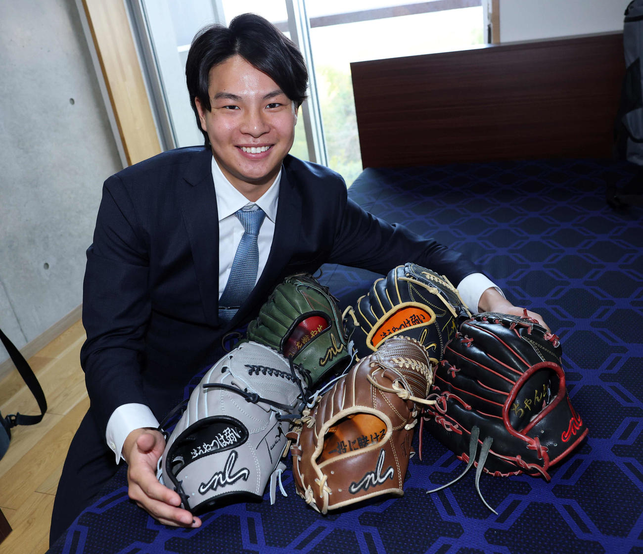 入寮した巨人ドラフト2位の田和は持ち込んだ大量のグラブを広げ笑顔