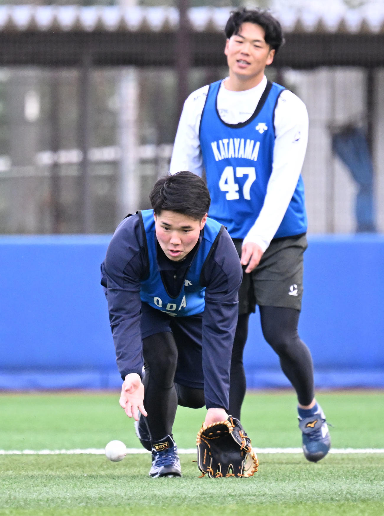 DeNAの新人合同自主トレでノックを受けるドラフト1位の小田。奥はドラフト4位の片山（撮影・千葉一成）