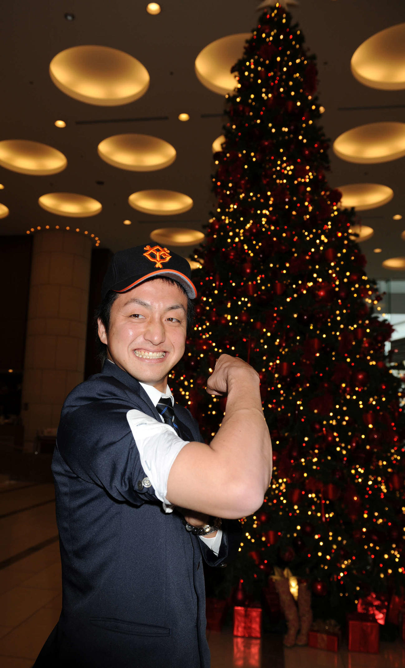 仮契約を終えた中大・沢村拓一は東京ドームホテルのクリスマスツリーの前で太い右腕を披露する（2010年11月撮影）