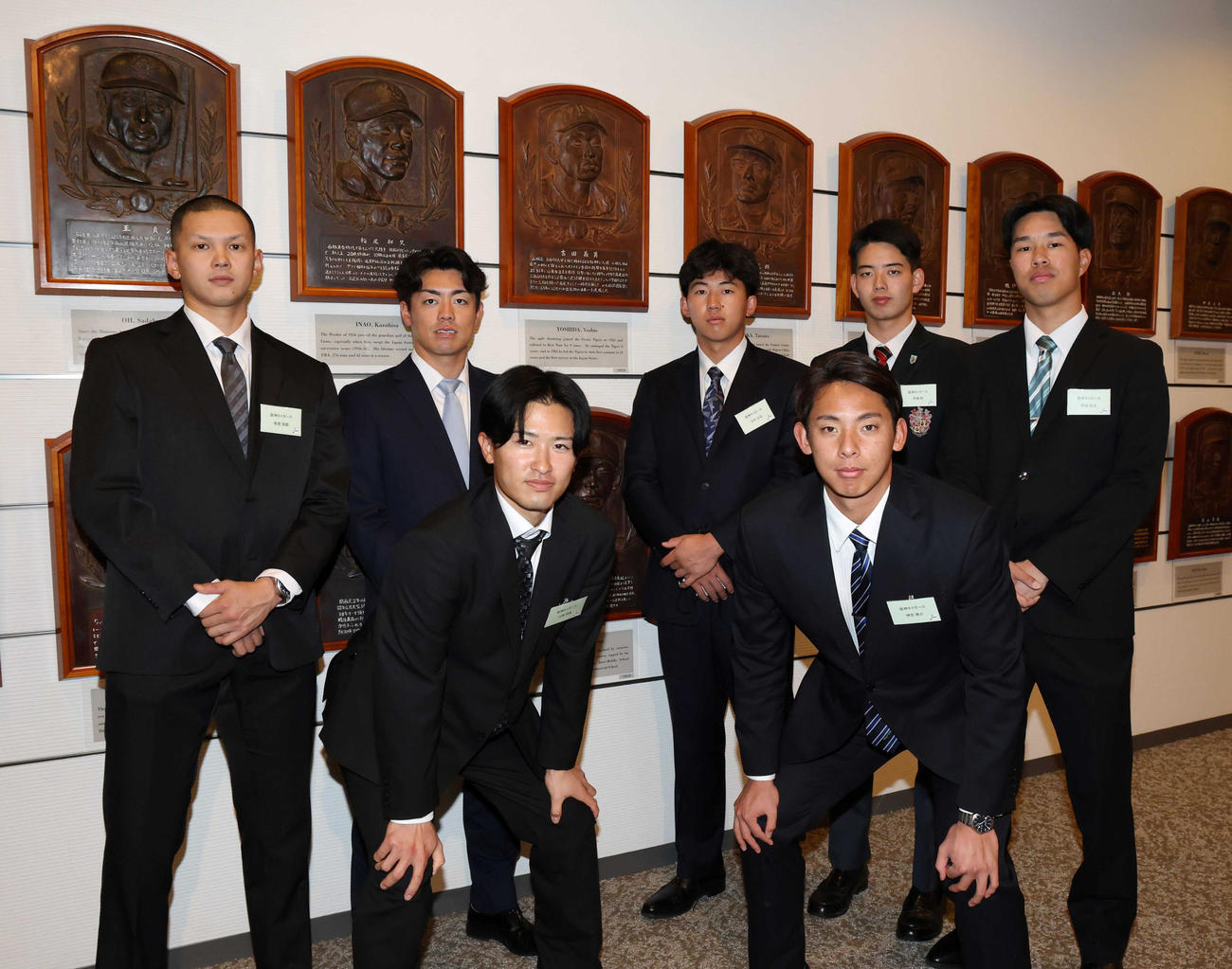 吉田義男氏のレリーフの前で記念撮影する阪神の新人選手たち。前列左から山崎、神宮、後列左から能登、谷端、立石、早瀬、岡城（代表撮影）
