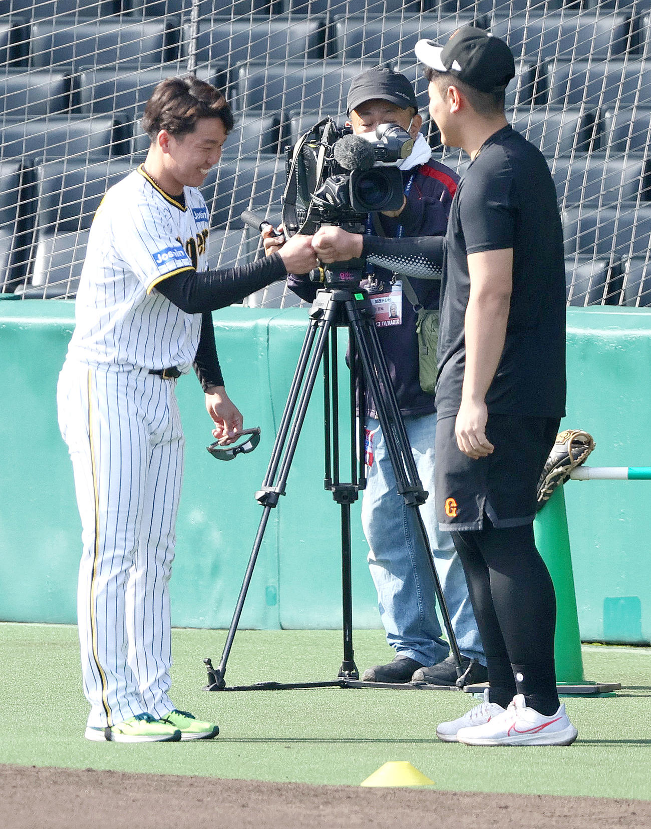 試合前の練習で阪神村上頌樹（左）は巨人岡本和真とタッチを交わす（2023年4月撮影）