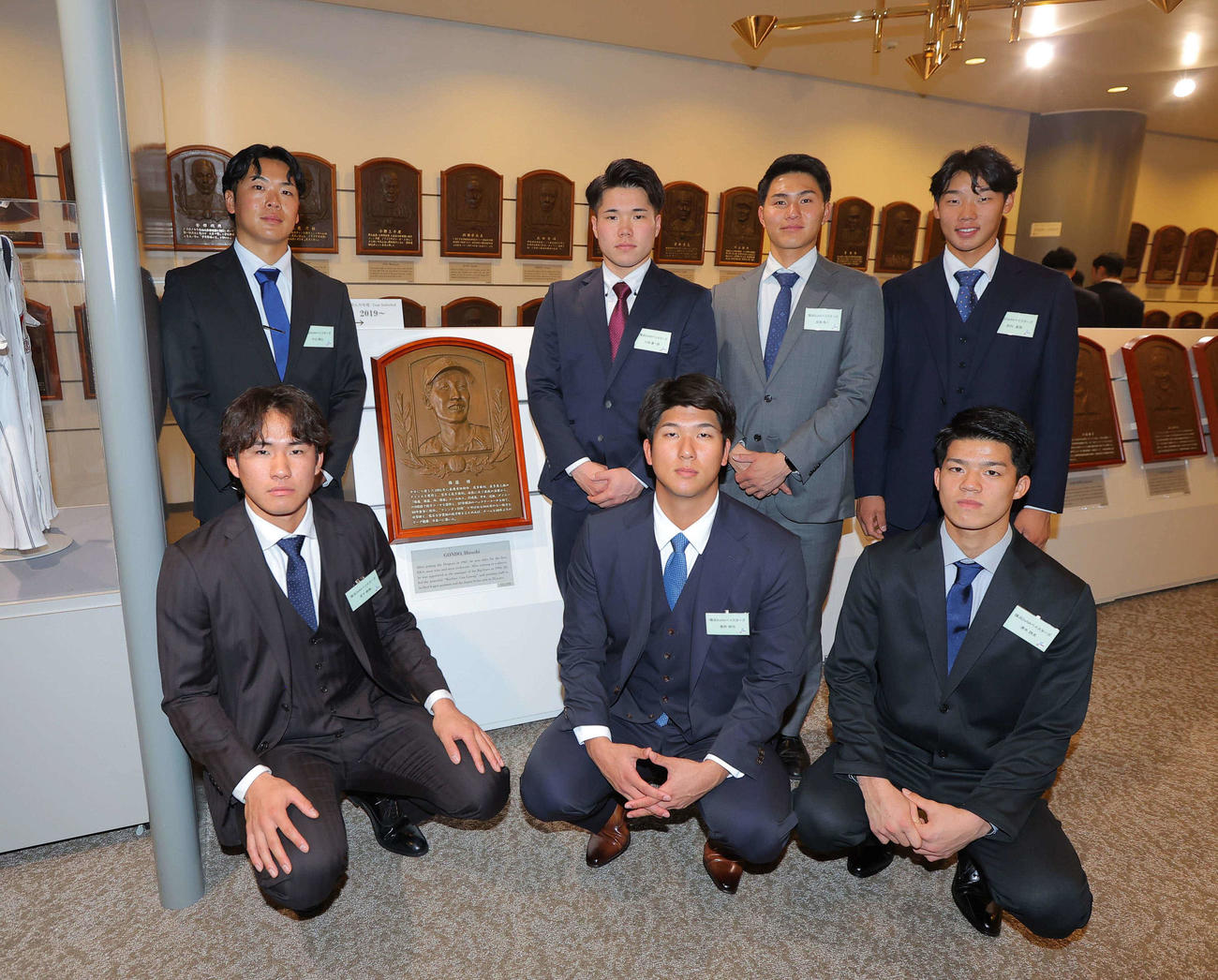 権藤博さんのレリーフの前で記念撮影をするDeNAナイン。前列左から宮下、島田、清水、後列左から片山、小田、成瀬、田内（代表撮影）