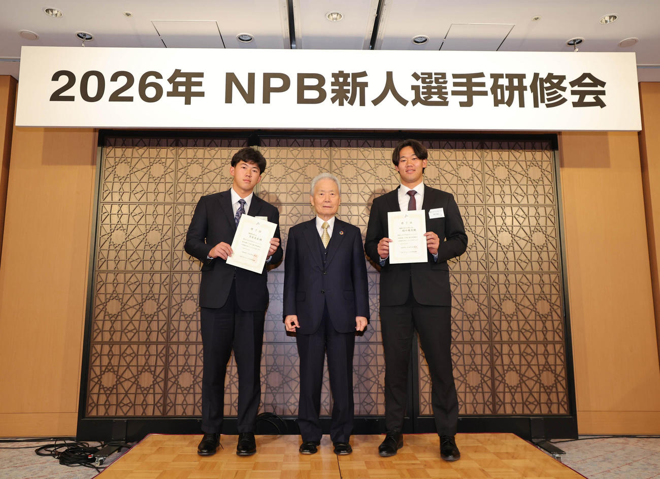 NPB新人選手研修会で榊原コミッショナー（中央）から修了証を受け取った阪神立石（左）とソフトバンク稲川（代表撮影）