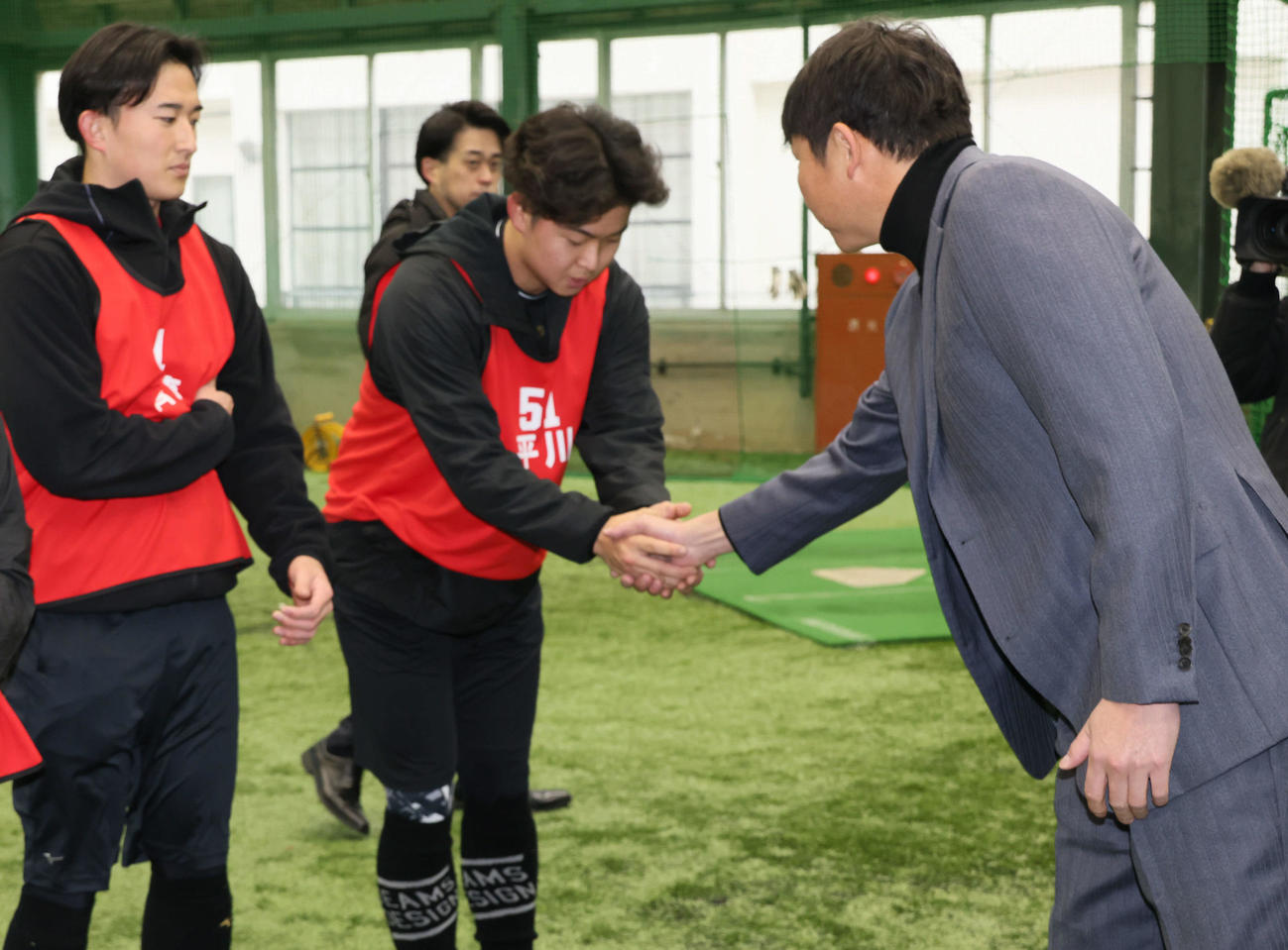 新入団選手合同自主トレを視察した広島新井監督（右）はドラフト1位の平川蓮と握手（撮影・加藤孝規）