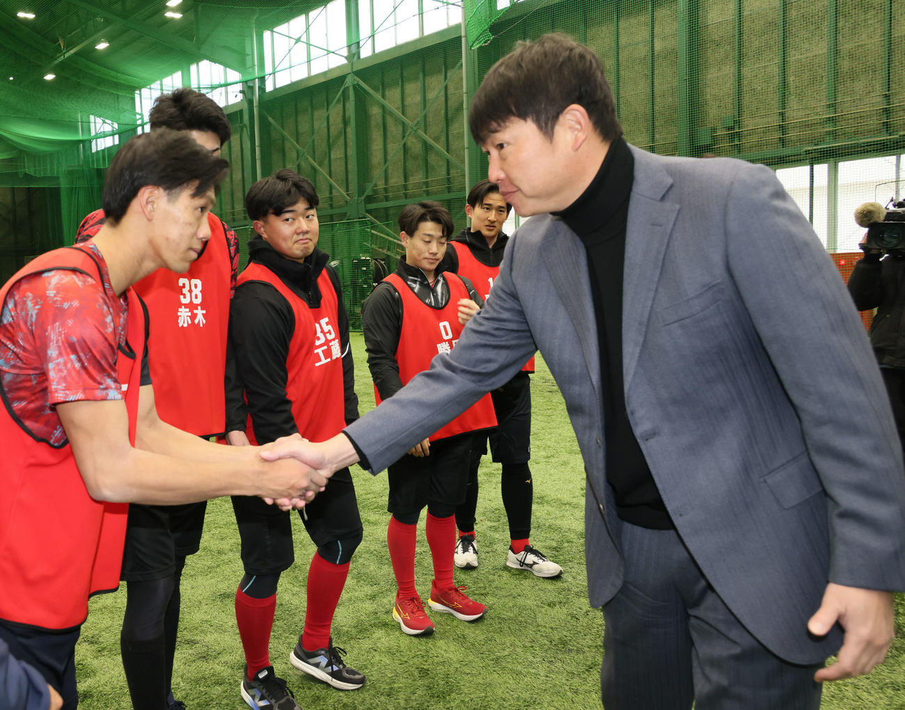 新入団選手合同自主トレを視察した広島新井監督（右）はドラフト6位の西川と握手（撮影・加藤孝規）