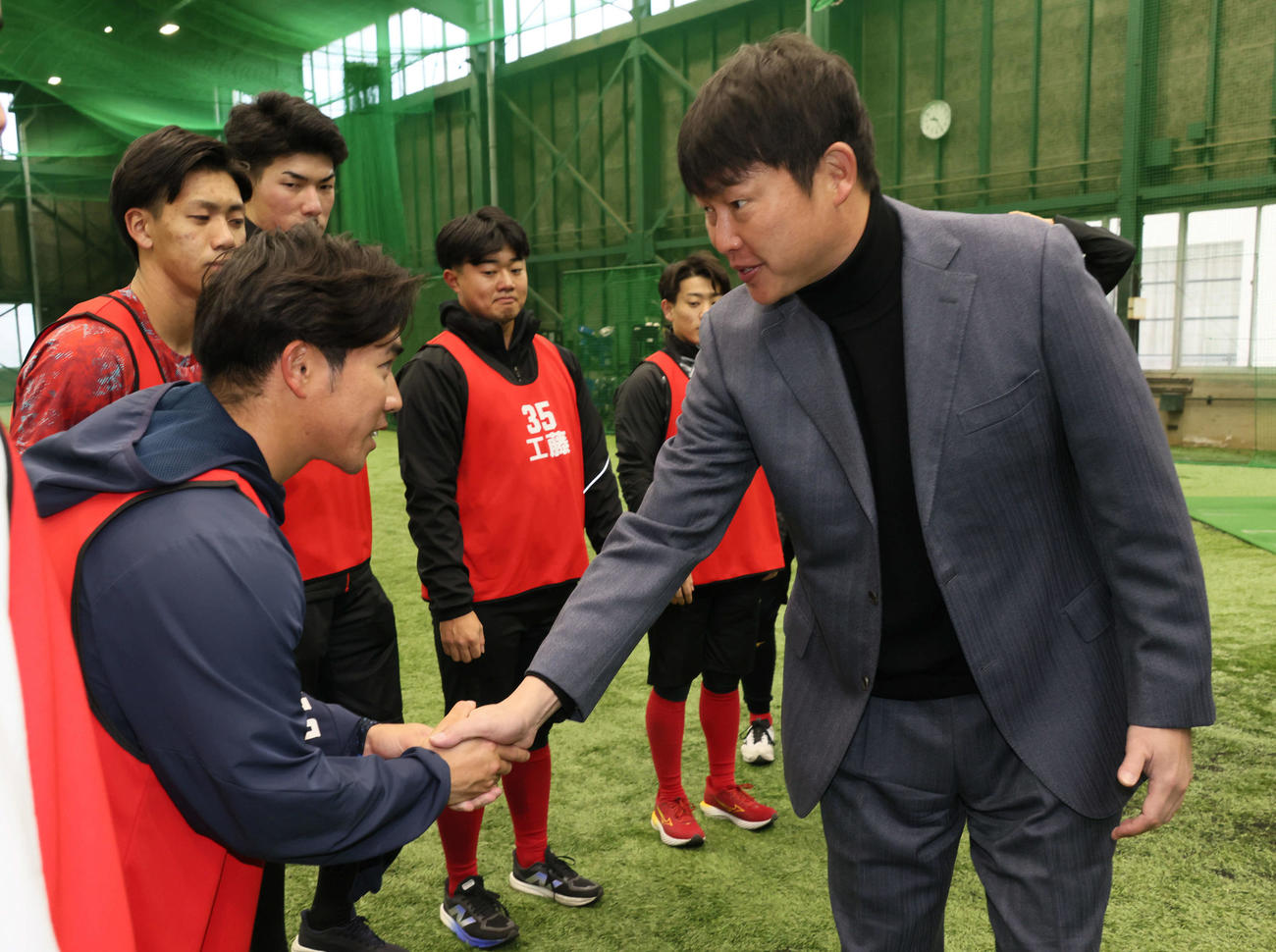 新入団選手合同自主トレを視察した広島新井監督（右）は育成2位の岸本と握手（撮影・加藤孝規）