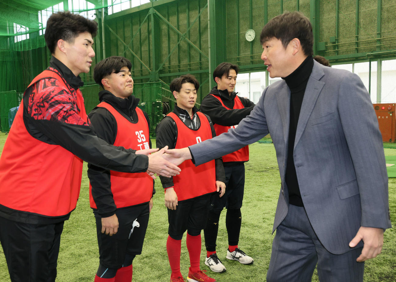 新入団選手合同自主トレを視察した広島新井監督（右）はドラフト5位の赤木と握手（撮影・加藤孝規）