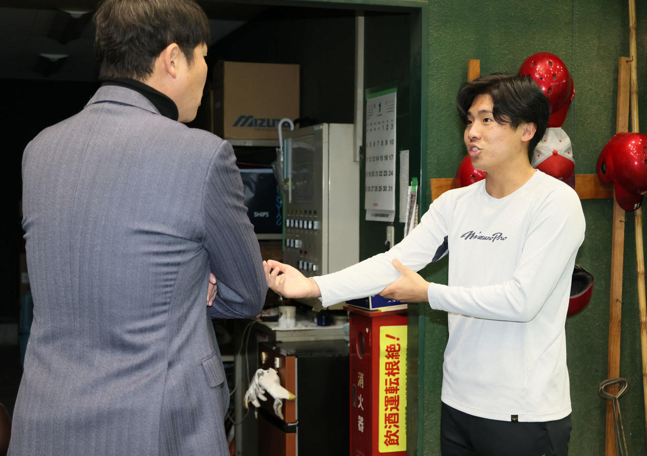 新入団選手合同自主トレを視察した広島新井監督（左）は別メニュー調整中のドラフト7位の高木快と話し合う（撮影・加藤孝規）