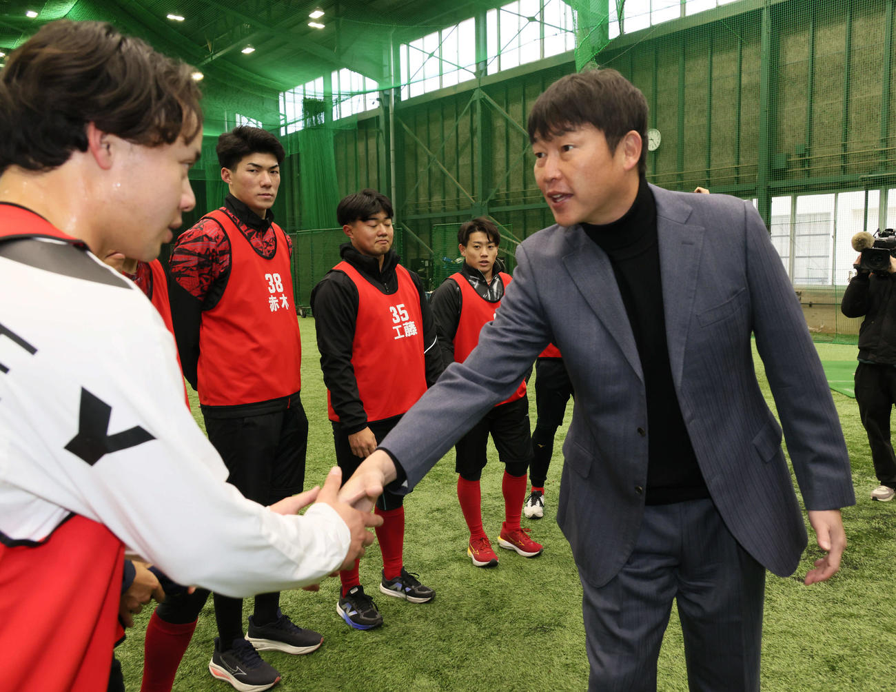 新入団選手合同自主トレを視察した広島新井監督（右）は育成1位の小林と握手（撮影・加藤孝規）