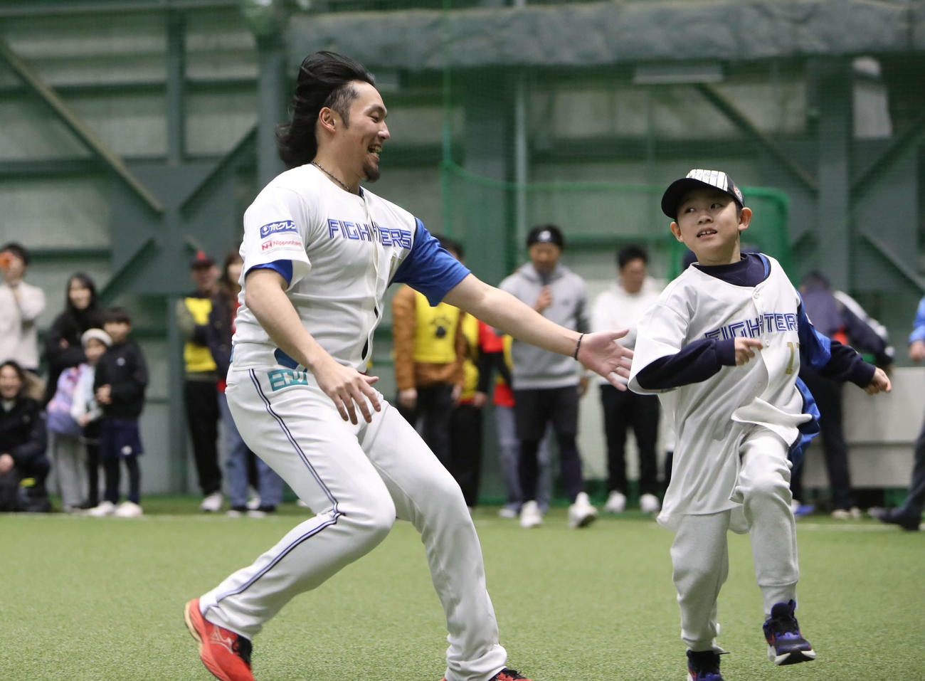 札幌市内で行われた野球教室で鬼ごっこに参加したに日本ハム伊藤