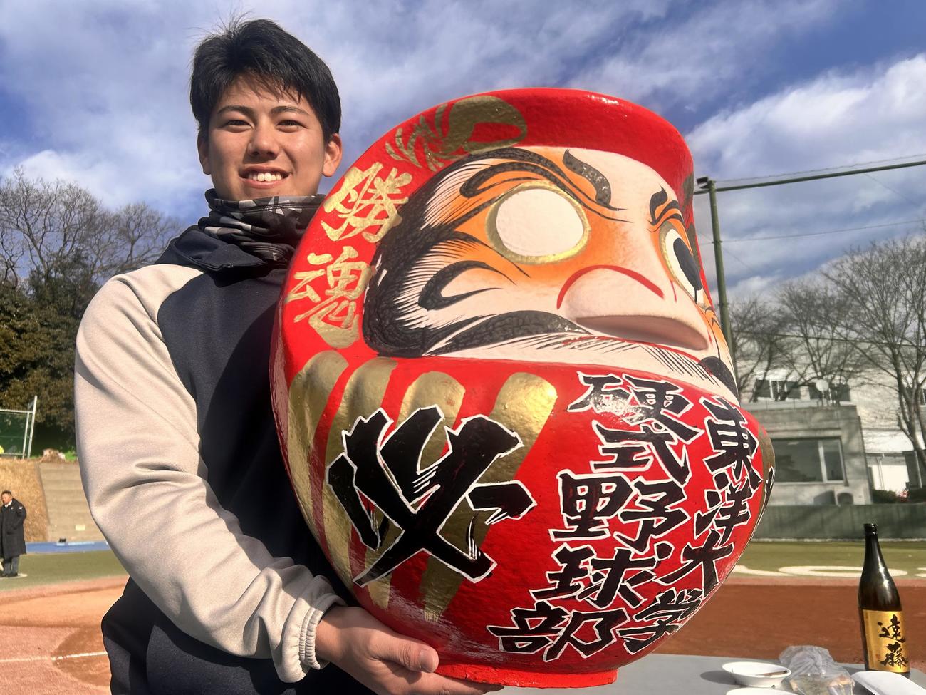 グラウンド開きで、目を入れたダルマを持つ東洋大・大坪（撮影・平山連）