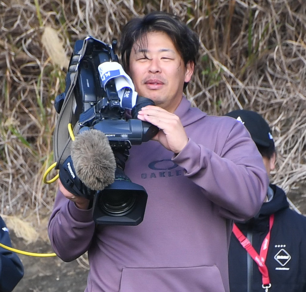 練習の合間にテレビカメラを持つ楽天浅村（撮影・山田愛斗）