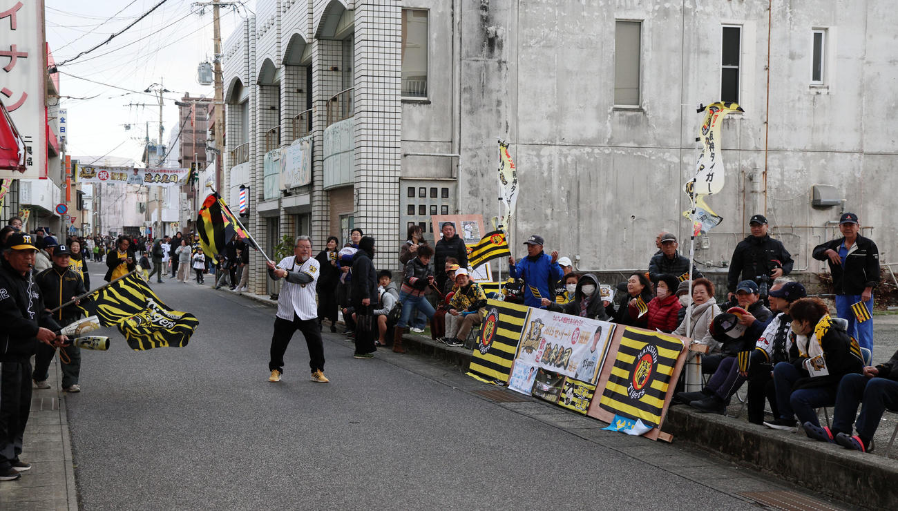 阪神近本の乗るパレード車両が近づくと球団旗を振って待ち受けるファンも現れた（撮影・加藤哉）