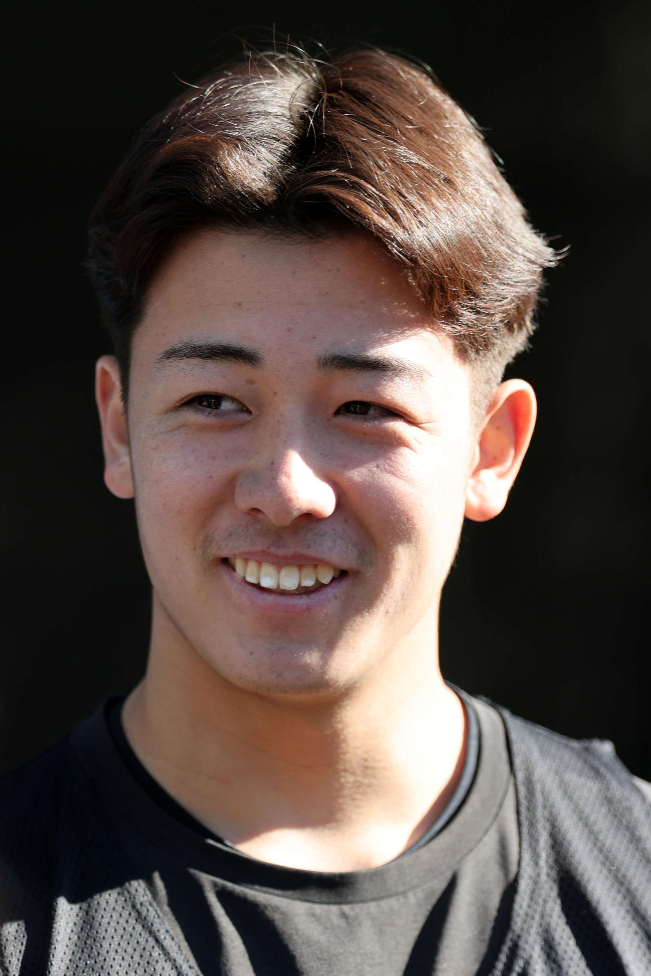 新人合同自主トレ後の囲み会見で、笑みを浮かべるロッテドラフト3位奥村（撮影・浅見桂子）