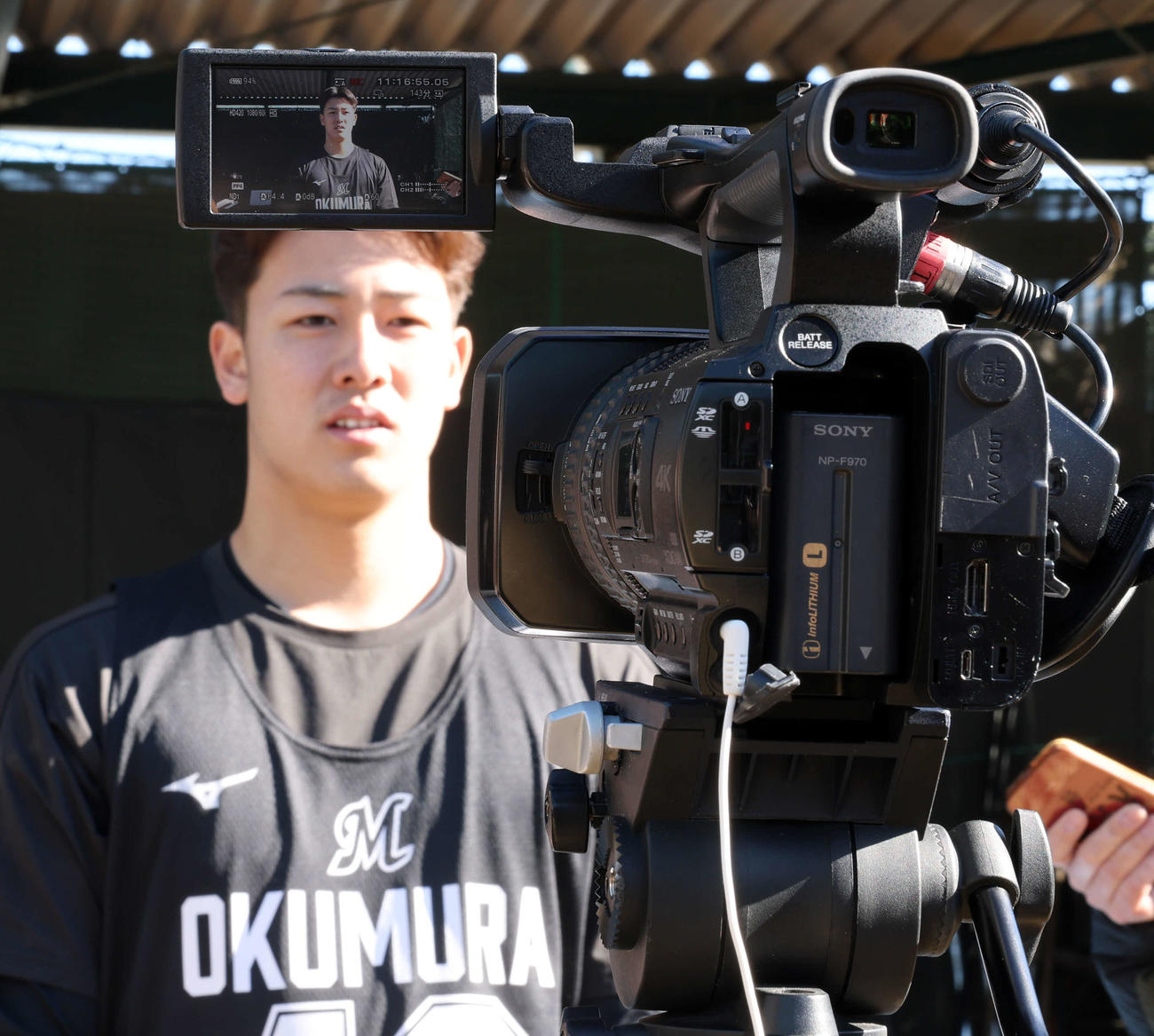 新人合同自主トレ後の囲み会見で、テレビカメラに緊張した表情のロッテドラフト3位奥村（撮影・浅見桂子）