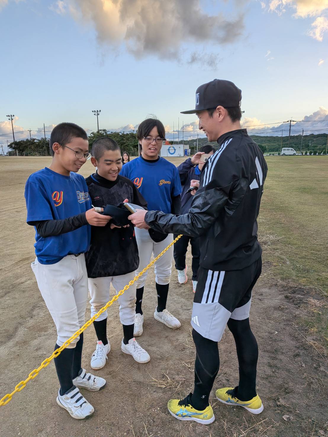 自主トレの合間に与論島の中学生にサインする阪神近本（撮影・柏原誠）