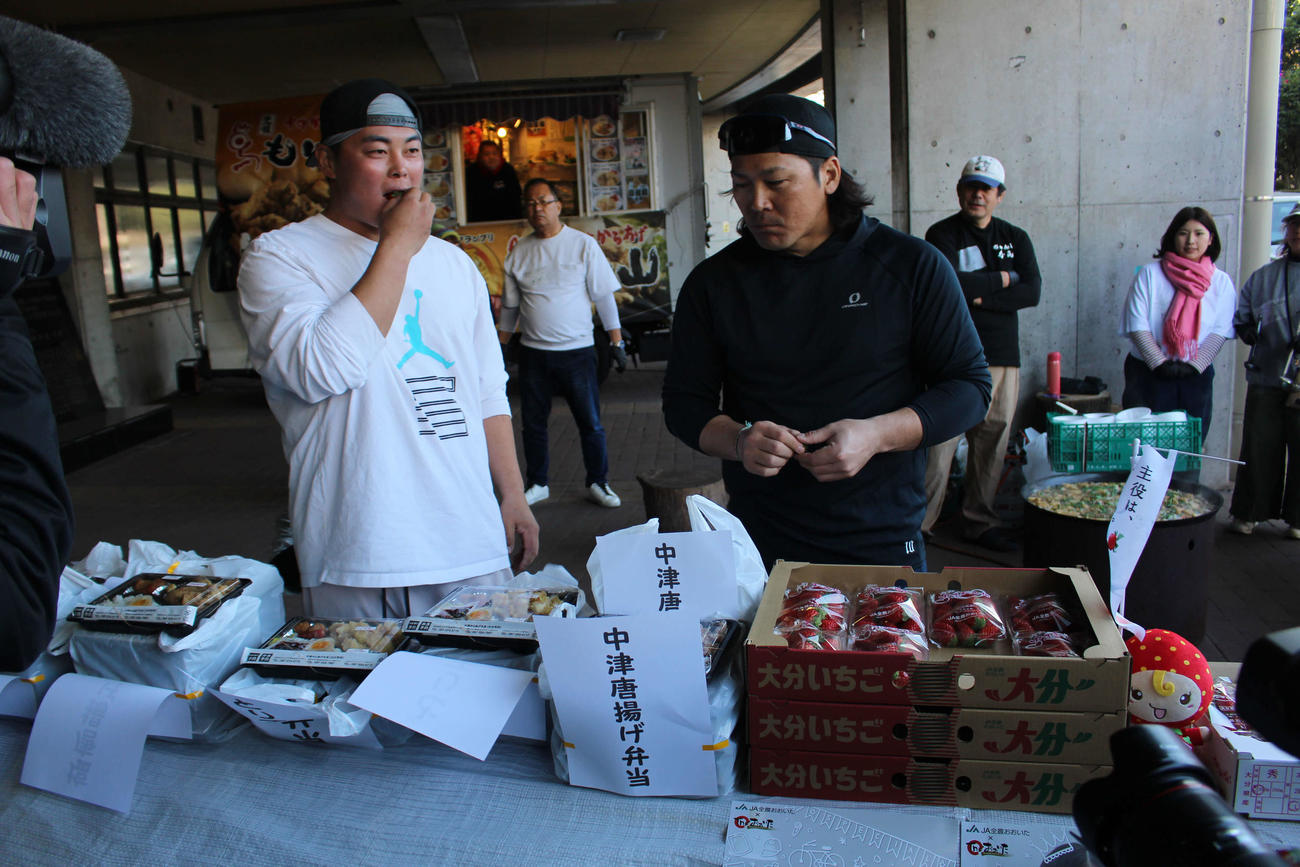 昼食で報道陣に中津からあげ弁当、いちごなどを振る舞う甲斐と山瀬（左）
