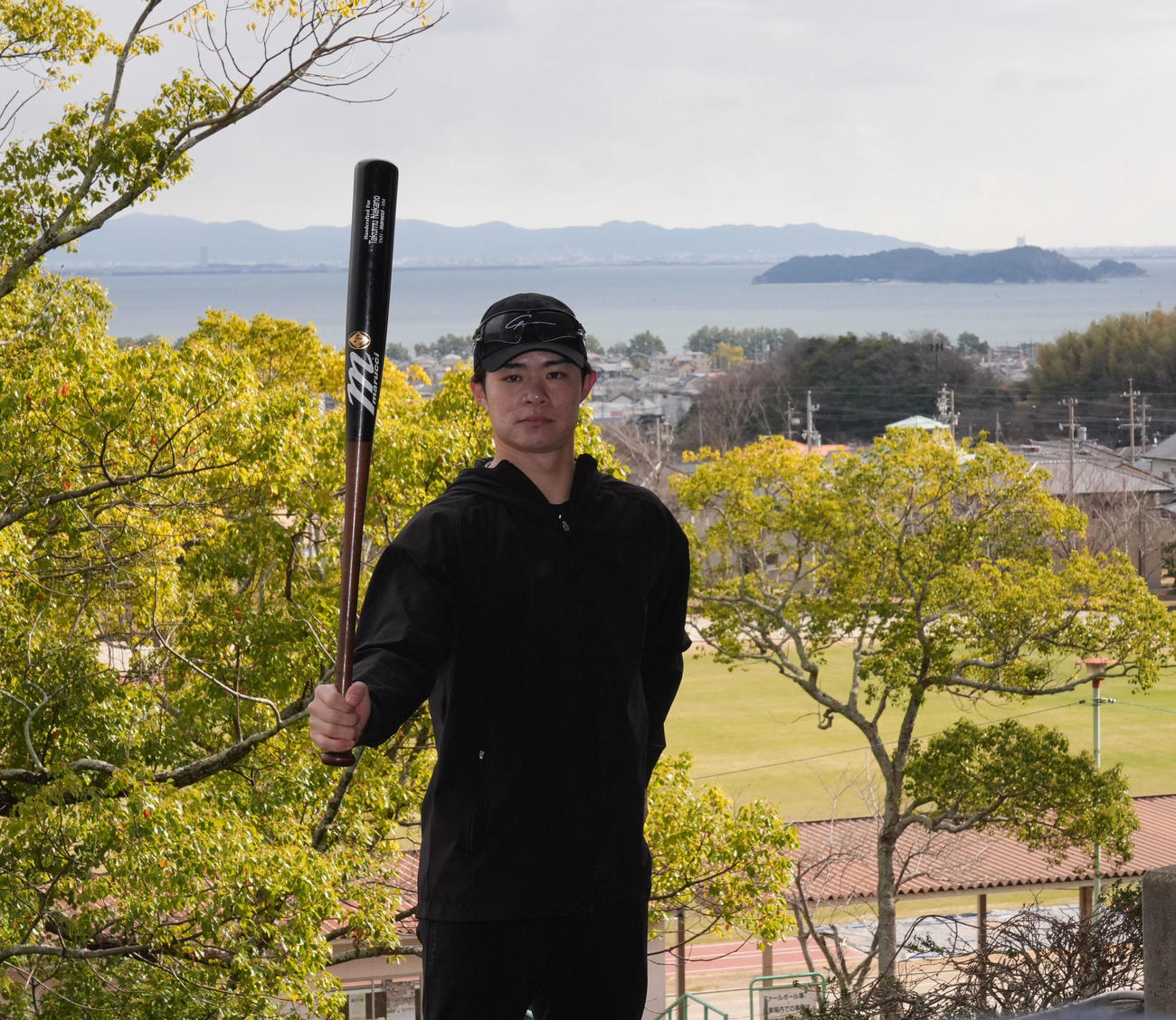 報道陣からのリクエストに応え三河湾を背にバットを手にポーズを決める阪神中野（撮影・森本幸一）