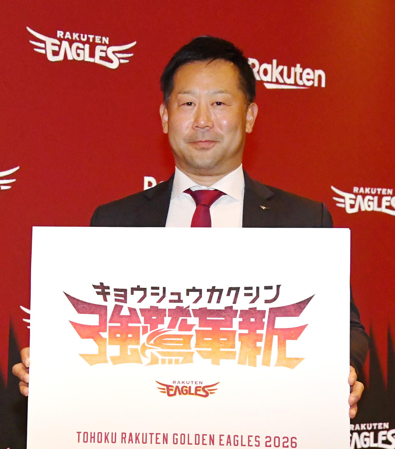 26年シーズンのチームスローガン「強鷲革新」のボードを持つ楽天三木監督