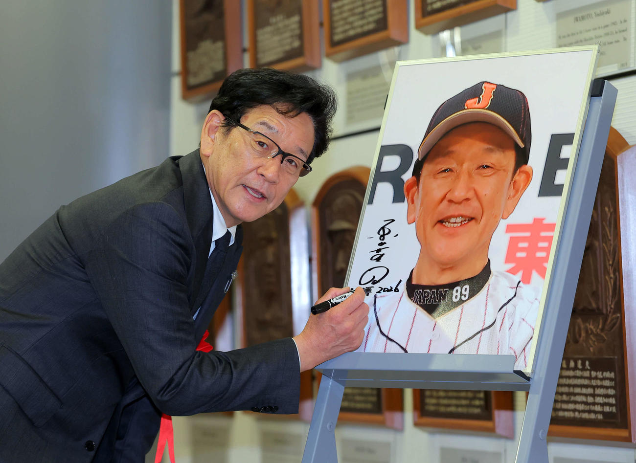 自身の写真にサインをする栗山英樹氏