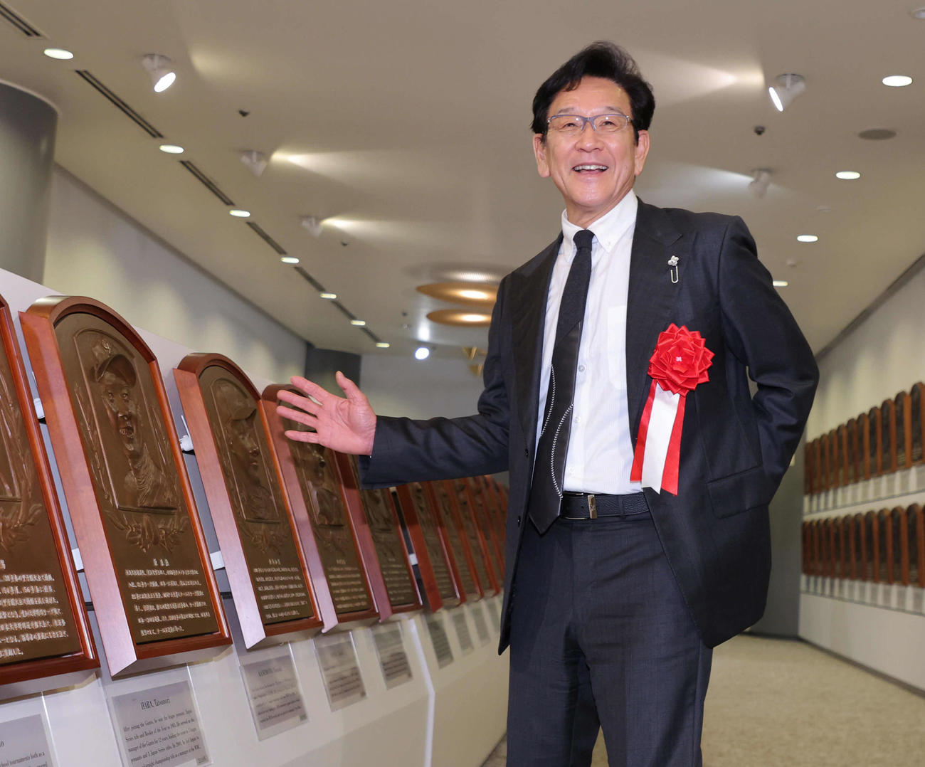 原辰徳氏のレリーフの前で記念撮影に納まる栗山英樹氏