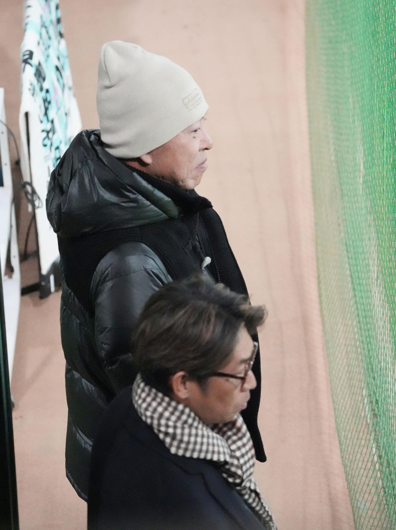 ルーキーたちのブルペン投球練習を見つめる中日井上監督（奥）手前は山井投手コーチ（撮影・森本幸一）