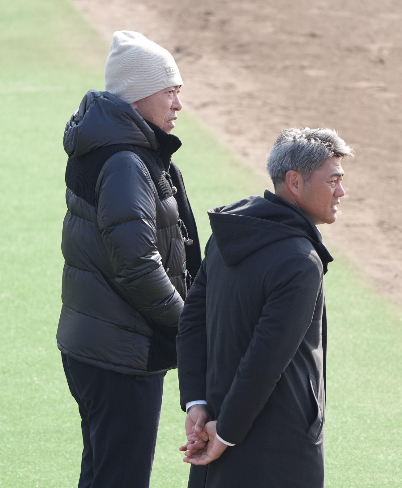スタッフ会議前、選手たちの自主トレを見つめる中日井上監督（左）右は飯山2軍監督（撮影・森本幸一）