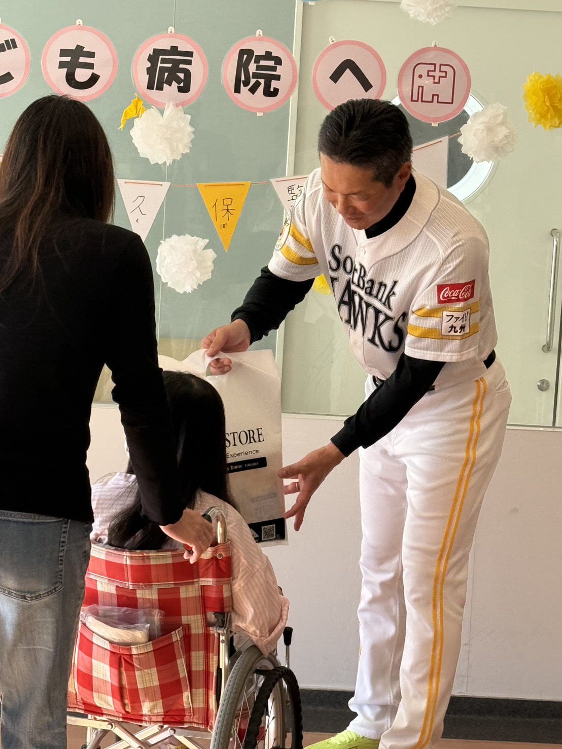 福岡市立子ども病院を訪れたソフトバンク小久保監督（右）はこどもに記念品を渡す