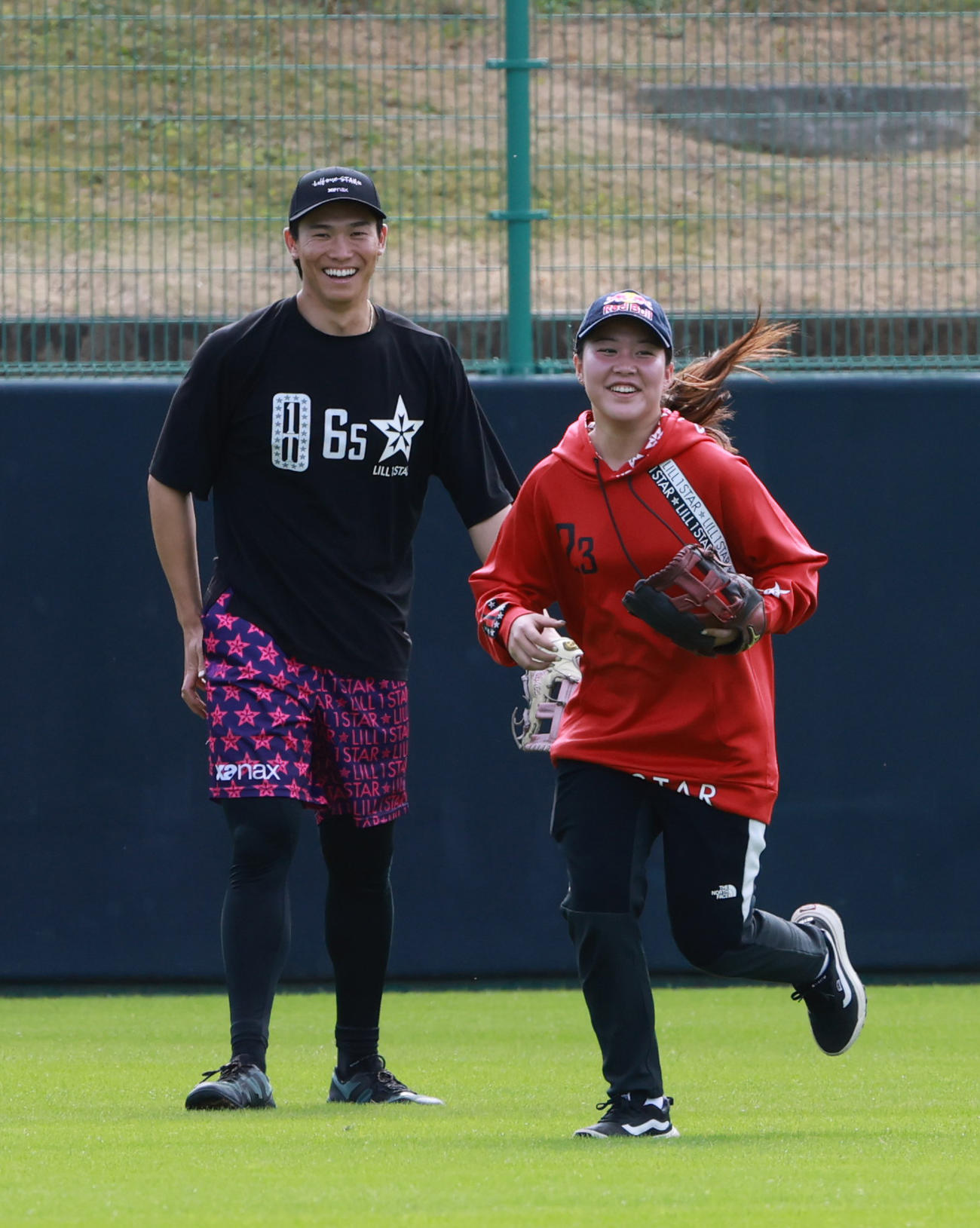 笑顔でノックを受ける阪神湯浅（左）と女子スケートボーダーの草木（撮影・上田博志）
