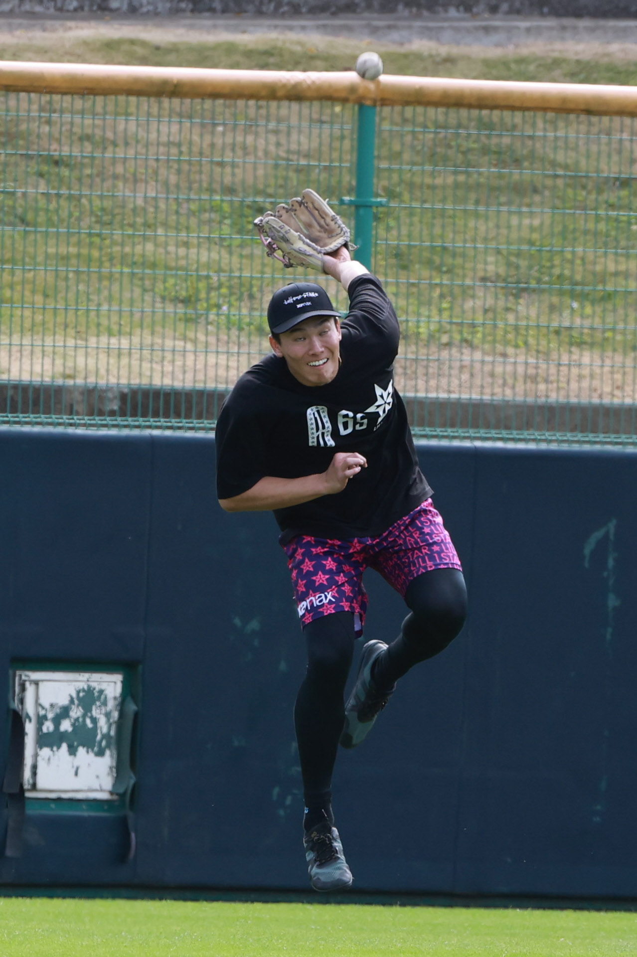 外野ノックを受ける阪神湯浅は背面キャッチを試みる（撮影・上田博志）